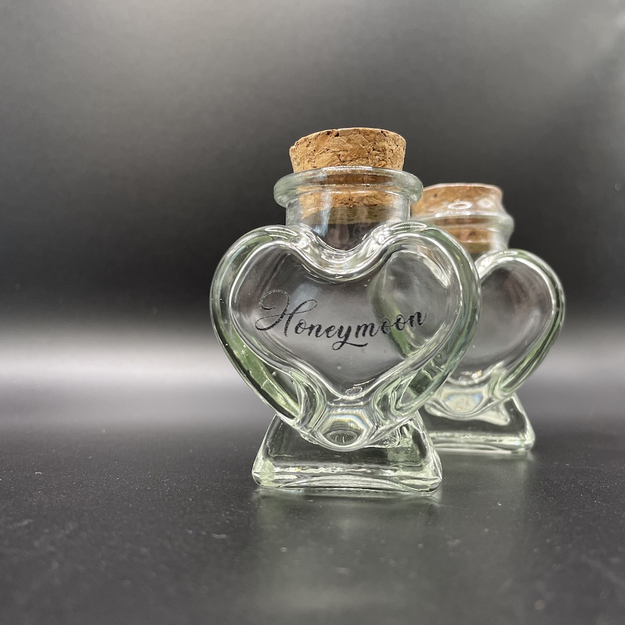 Hartvormig glazen potje met zwarte tekst